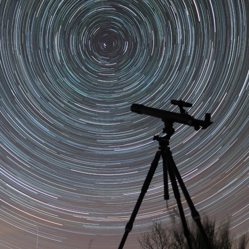 telescope against a time-lapse of stars